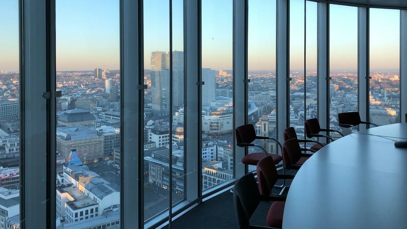 Executive boardroom overlooking a city at sunset