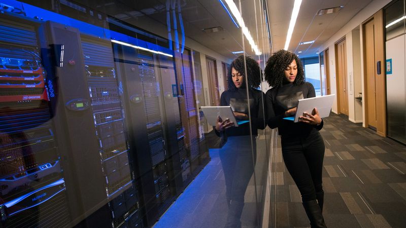 Engineer with a laptop in a data center corridor